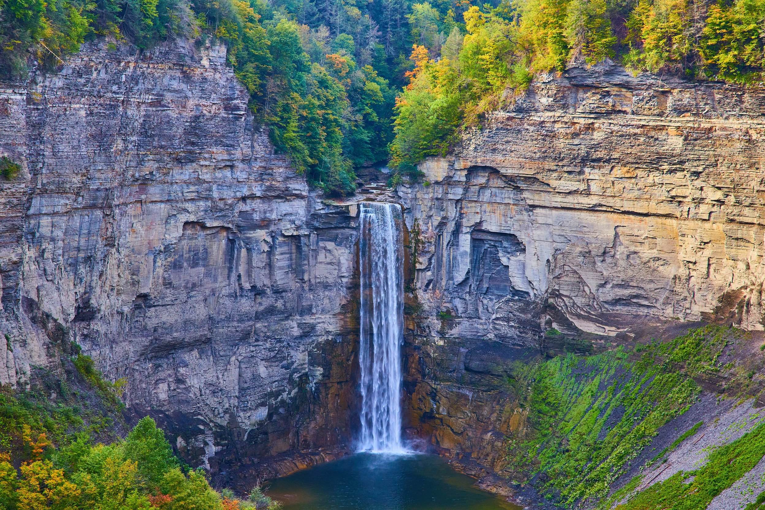 Huge Waterfall Flowing into Large Canyon with Rocky Cliffs.Jpg